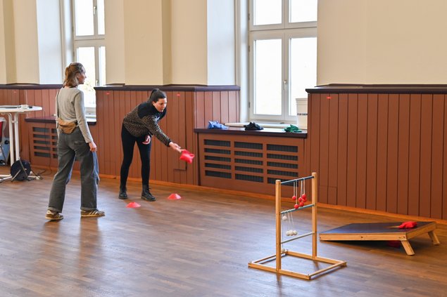 Zwei Teilnehmerinnen spielen in der Pause das Säckchenspiel Cornhole